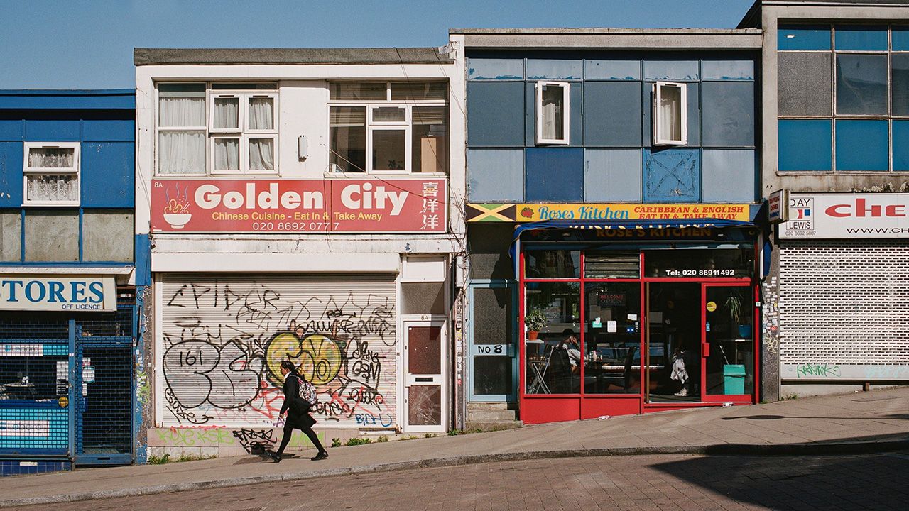 A school girl walks past a line of run down shops in Britain.