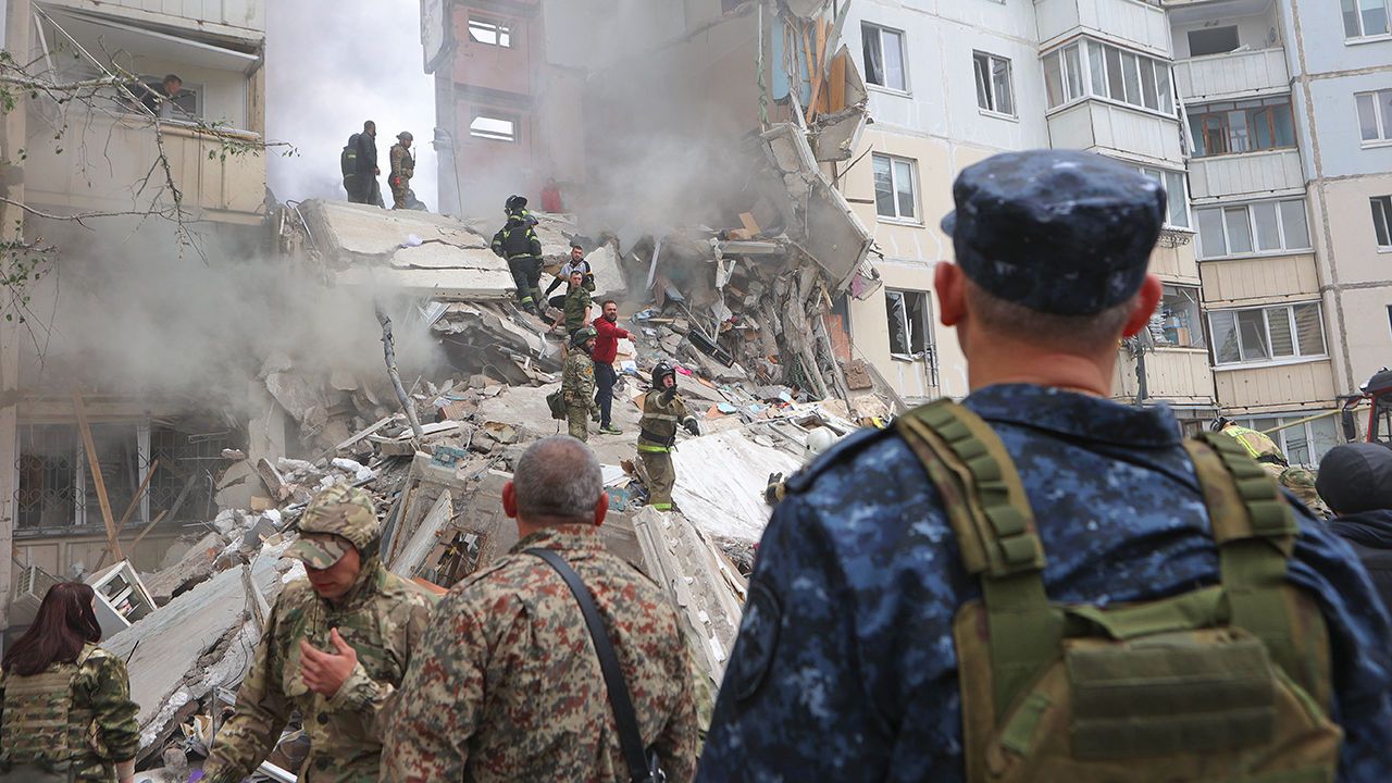 Officials work on the site of a Ukrainian missile strike at an apartment in Belgorod, Russia