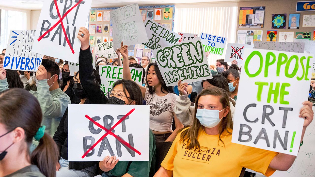 Students against the CRT ban make their views known while pro-ban speakers give a talk.