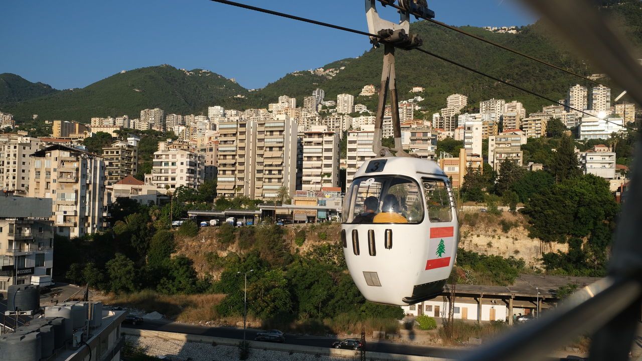 A cable car with the Lebanese flag on the side is seen going up and down on the line connecting seaside road to the hill top in Jounieh, Lebanon.