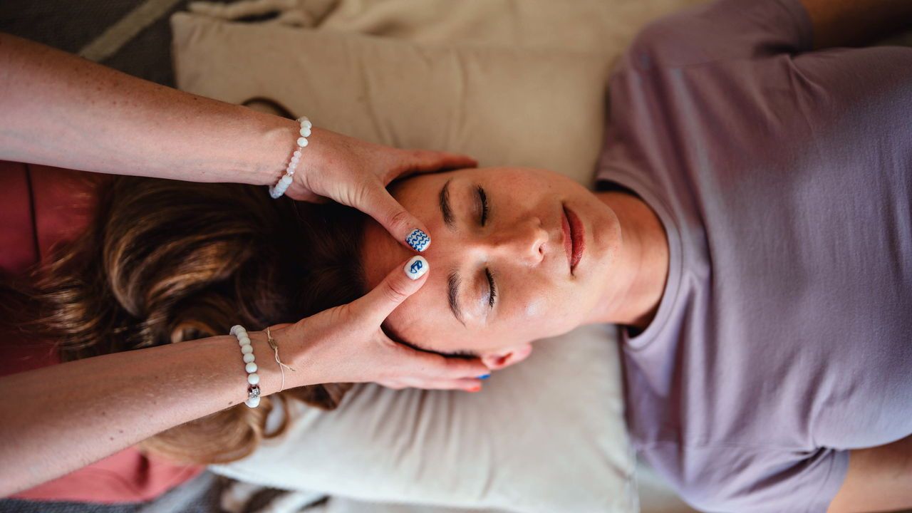 A woman is given a face massage.